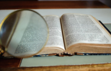 Fototapeta premium Old vintage book and magnifying glass