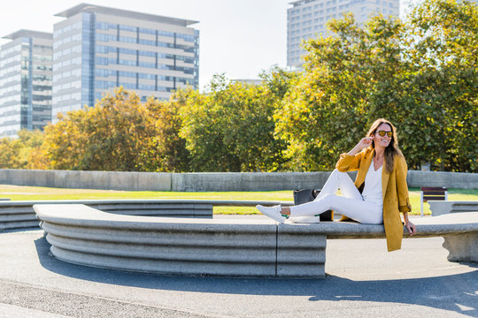 Happy woman sitting on a bench in the city