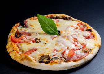 fresh italian pizza on black background