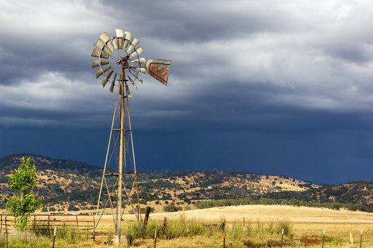 Windmill with stormy skies and sunlight on the ground