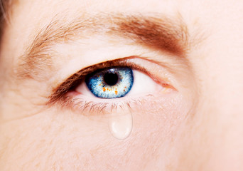 A beautiful insightful look woman's eye with tear drop. Close up shot