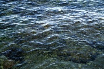 A surface of water in the sea, wrinkled with light waves. Background.