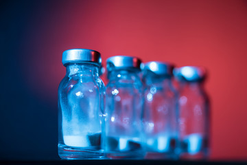 Bottles for injection with white powder on a color background