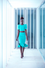 Attractive black woman wearing turquoise dress walks the runway