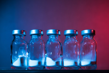 Bottles for injection with white powder on a color background