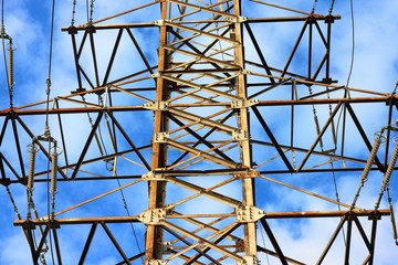 Metal support of high-voltage power line 110 kV. Transmission tower or electricity pylon with blue sky. Fragment