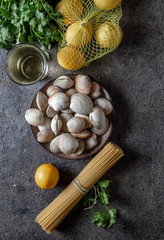 Fototapeta na wymiar Ingredients for preparation spaghetti with clams - raw fresh clams, spaghetti coriander, white wine lemon