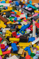 Fototapeta premium Close up of colorful plastic bricks on the floor. Early learning. Children's plastic constructor on the floor. background. vertical photo