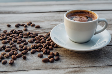 Turkish or Greek Hot Coffee on the white rustic wooden table with spilled coffee beans. This is traditional tasty refreshment greek or turkish coffee from greek or turkish cuisine culture