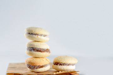 Delicious Argentinian cookies alfajores with cream dulce de leche on the table on paper bag, plastic free. Close up white vanilla macaroons on white background. French delicate dessert for breakfast.