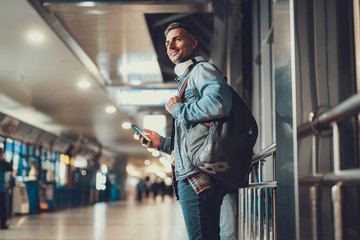 Attractive man holding telephone in hands and ready going in travel
