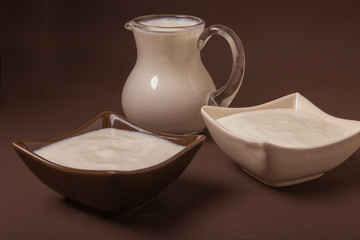 Homemade yogurt in ceramic square bowls, a jug brim full of yogurt behind the bowls. Healthy food from yogurt concept