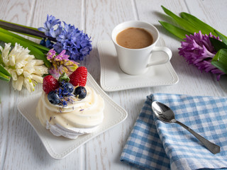 Sweet fruit cake with coffee cup and hyacinths flowers on the table.