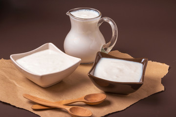 Homemade yogurt in ceramic square bowls, a jug brim full of yogurt behind the bowls. Healthy food from yogurt concept
