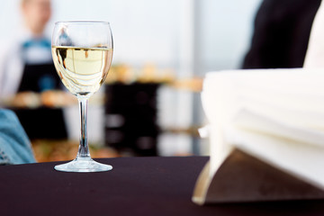 a glass of white wine on a table with a black tablecloth 
