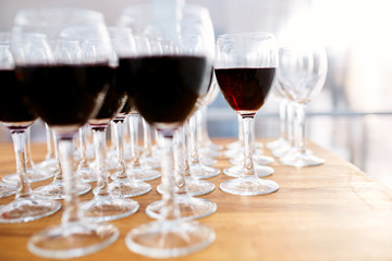 Many glasses with red wine and empty wine glasses 