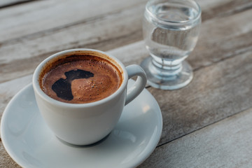 Turkish or Greek Hot Coffee on the white rustic wooden table with spilled coffee beans. This is traditional tasty refreshment greek or turkish coffee from greek or turkish cuisine culture