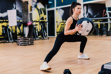 Athletic young woman doing exercise with med ball. Strength and motivation.