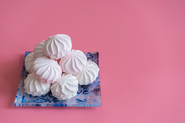 Pink and white marshmallows on a pink background. copy space.
