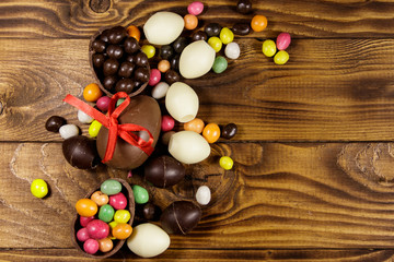 Easter composition with chocolate eggs on wooden background