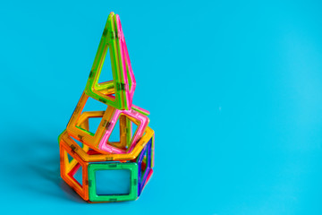 Children's bright color magnetic constructor on blue background. intellectual toy. copy space