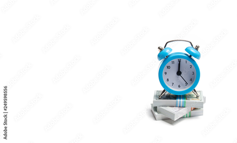 Wall mural a clock is standing on a bunch of packs of money on a white background. the concept of expressing ti