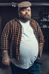 Attractive man looking in camera and standing in hair cutting salon