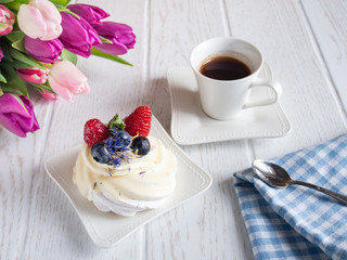  Sweet fruit cake with coffee cup and flowers on the table.