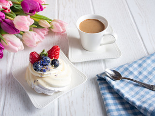 Sweet fruit cake with coffee cup and flowers on the table.