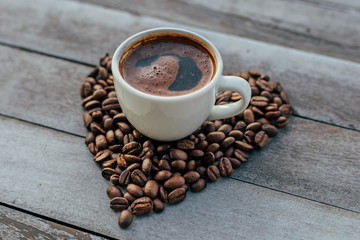Turkish or Greek Hot Coffee on the white rustic wooden table with spilled coffee beans. This is traditional tasty refreshment greek or turkish coffee from greek or turkish cuisine culture