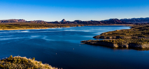 Aerial, drone view of Alamo Lake, Arizona in the remote desert near Wenden with vivid blue water...