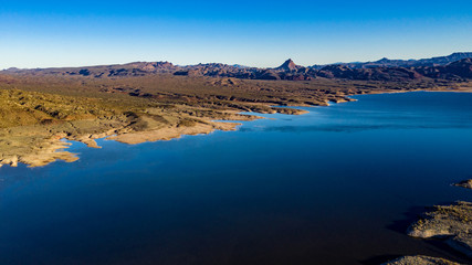 Aerial, drone view of Alamo Lake, Arizona in the remote desert near Wenden with vivid blue water and sky with Alamo Dam