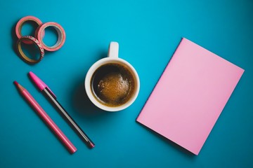 notebook and cup of coffee on blue table