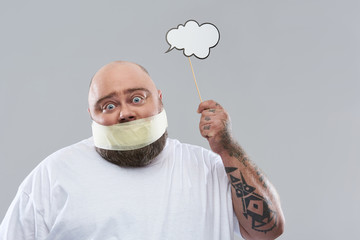 Man with thought cloud having masking tape on the mouth