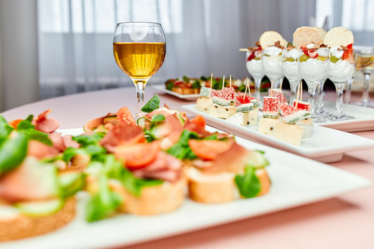 bruschetto with tomato and basil on a plate and a glass of white wine 