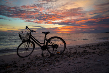 Fototapeta premium Sunset silhouette of vintage bicycle on the beach 