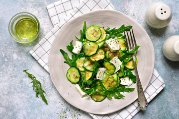 Grilled zucchini salad with feta cheese and arugula.Top view with copy space.
