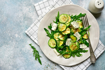 Grilled zucchini salad with feta cheese and arugula.Top view with copy space.