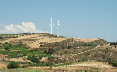 Wind Farm and Olive field with blue sky and clouds at Crete Island, Greece