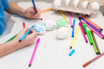 A child will paint Easter eggs with felt-tip pens. Easter ideas. Space for text. Egg tray. Happy easter.