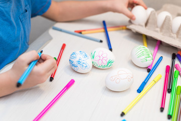 A child will paint Easter eggs with felt-tip pens. Easter ideas. Space for text. Egg tray. Happy easter.