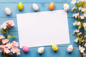 Frohe Ostern Hintergrund mit bunten Ostereiern und einem weißen Zettel