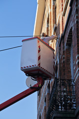 électricien sur élavateur réparant boitier électrique façade maison