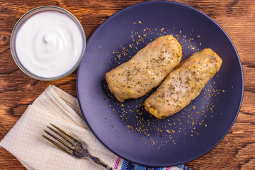 Stuffed cabbage rolls with sour cream on plate