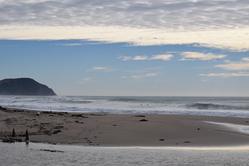Waves start to roll in on to the empty beach in Gisborne, New Zealand.