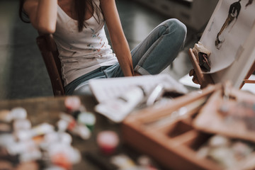 Selective focus of female artist sitting next to the easel