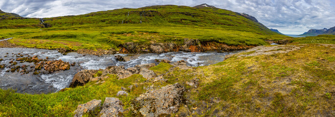 Panoramic view of wilderness of fjord landscape and Selbrekkufoss waterfall near Seydisfjordur on...