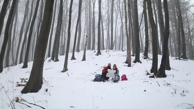 Young couple reading the map in forest