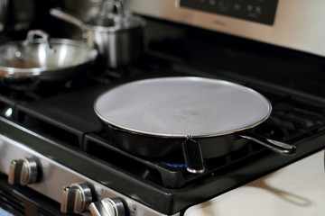 Splatter screen on cast iron pan to prevent grease mess on the stove.