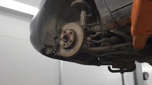 brake disk of the car on the lift in the service station